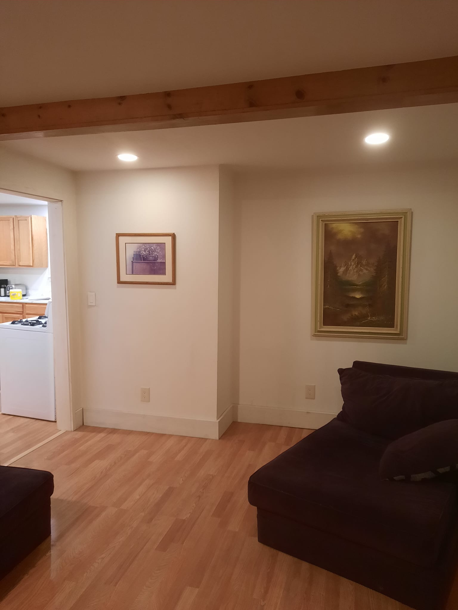 Completed living room restoration showing refinished hardwood and new paint.